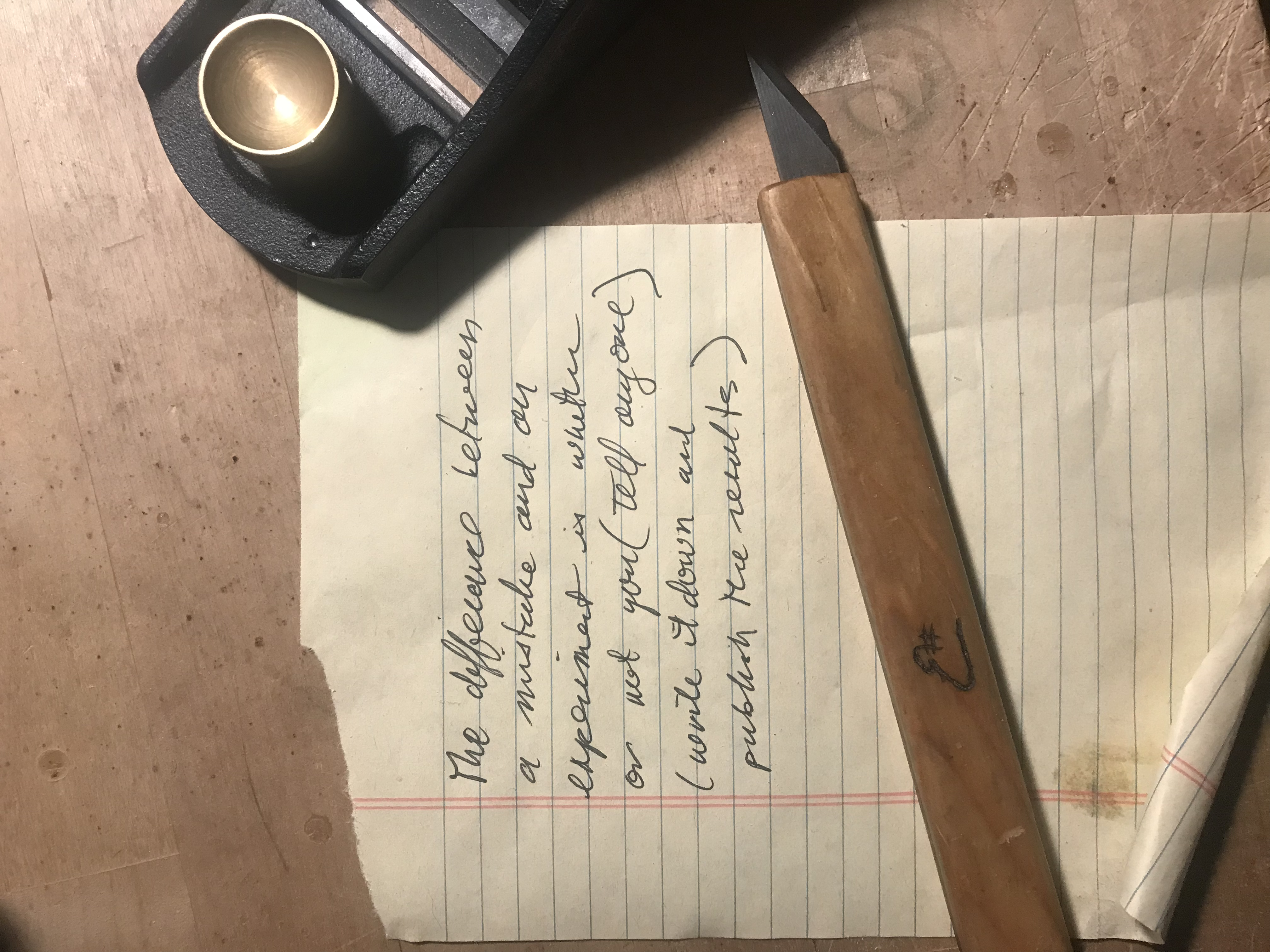 Yellow legal pad paper in Craig Danner's handwriting, reading: The difference between a mistake and an experiment is whether or not you (tell anyone)(write it down and publish the results.)
